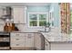 Bright kitchen with white cabinets, granite countertops, subway tile backsplash, and stainless steel appliances at 25 Highlands Way, Oxford, GA 30054