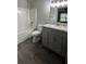 Well-lit bathroom with gray cabinets, granite countertops, and tub with shower at 3204 Fairington Village Dr, Lithonia, GA 30038