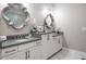 Bathroom vanity features double sinks, white cabinets with gold hardware, gray countertops, and decorative mirrors at 623 Brennan Dr, Decatur, GA 30033