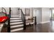 Staircase with dark wood treads and white risers, complemented by a cozy hanging chair and stylish decor at 623 Brennan Dr, Decatur, GA 30033