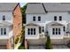 Rear exterior view of townhomes with white siding, brick accents, and garage access at 623 Brennan Dr, Decatur, GA 30033