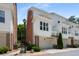 Townhome exterior featuring brick accents, white siding, and covered garage entrances at 623 Brennan Dr, Decatur, GA 30033