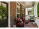Inviting front porch with brick flooring, comfortable seating, and a welcoming wreath on the front door at 623 Brennan Dr, Decatur, GA 30033