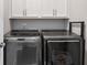 Laundry room features modern washer and dryer with overhead storage cabinets at 623 Brennan Dr, Decatur, GA 30033