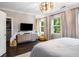 Spacious bedroom with a modern light fixture, large windows and TV at 623 Brennan Dr, Decatur, GA 30033