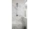 Detailed marble tilework in this open shower with a seating bench and showerhead with a hose at 623 Brennan Dr, Decatur, GA 30033