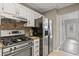 Updated kitchen with stainless steel appliances and tile backsplash at 3444 Washington Way, Atlanta, GA 30340