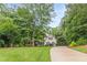 Home with a sprawling green lawn and mature trees lining the long driveway, offering beauty and privacy at 5767 Wembley Dr, Douglasville, GA 30135