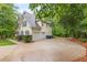 Side view of home, driveway, and attached garage, all enhanced by lush landscaping and natural surroundings at 5767 Wembley Dr, Douglasville, GA 30135