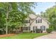 Charming two-story home with a lush front yard and welcoming porch with black shutters on windows at 5767 Wembley Dr, Douglasville, GA 30135