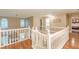 Bright hallway with white railing overlooking living area and featuring wood floors at 5767 Wembley Dr, Douglasville, GA 30135