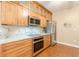 Well-equipped kitchen features wood cabinets, stainless appliances, and granite counters at 5767 Wembley Dr, Douglasville, GA 30135