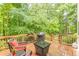Backyard wooden deck with seating and grill, offering outdoor entertaining in wooded setting at 5767 Wembley Dr, Douglasville, GA 30135