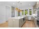 Bright kitchen with an island, stainless steel appliances, stone countertops, pendant lights, and hardwood flooring at 205 Mayfair Ct, Alpharetta, GA 30009