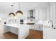 Large, open kitchen features stainless steel appliances, white cabinets, an island, and hardwood floors at 205 Mayfair Ct, Alpharetta, GA 30009