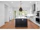 Spacious kitchen with stainless steel appliances, white cabinets, a dark island with quartz counters, and hardwood floors at 205 Mayfair Ct, Alpharetta, GA 30009