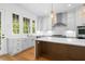 Bright kitchen with white cabinets, center island, stainless steel appliances, and tile backsplash at 205 Mayfair Ct, Alpharetta, GA 30009