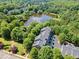 Aerial view of a building complex surrounded by a lush landscape and a pond at 2766 Wander Ln, Alpharetta, GA 30022
