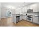 Beautiful kitchen with stainless steel appliances, granite countertops, and white cabinets blends seamlessly into dining area at 2766 Wander Ln, Alpharetta, GA 30022
