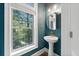 Stylish powder room with a pedestal sink, designer wallpaper, and ample natural light at 2766 Wander Ln, Alpharetta, GA 30022