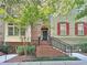 Charming townhouse with brick facade, red shutters, and an inviting front entrance with beautiful landscaping at 2766 Wander Ln, Alpharetta, GA 30022