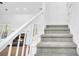 Carpeted staircase leading to a living area with a fireplace and natural light from the french doors at 3110 Haverhill Ne Cv, Conyers, GA 30012