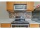Close-up of stove area with microwave and decorative backsplash tiles at 3623 Thurleston Sw Ct, Marietta, GA 30008