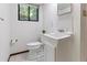 Well-lit half bathroom features a white sink, toilet, and a window at 431 Keeler Woods Nw Dr, Marietta, GA 30064