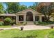 Charming brick home with a covered porch, landscaped front yard, and a patterned concrete driveway at 431 Keeler Woods Nw Dr, Marietta, GA 30064