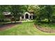 Beautifully landscaped home with a lush lawn, mature trees, and a welcoming covered porch, offering curb appeal at 431 Keeler Woods Nw Dr, Marietta, GA 30064
