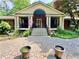 Charming brick home with a covered porch, manicured landscaping, and a patterned concrete driveway at 431 Keeler Woods Nw Dr, Marietta, GA 30064