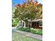 Charming brick home with covered porch, American flag, and beautiful mature tree in front yard at 431 Keeler Woods Nw Dr, Marietta, GA 30064