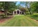 Beautifully landscaped front yard with a brick home and mature trees on a large green lawn at 431 Keeler Woods Nw Dr, Marietta, GA 30064