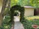 View of tranquil landscaped yard featuring an ivy-covered archway and stone pathway at 431 Keeler Woods Nw Dr, Marietta, GA 30064