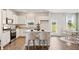 Well-lit kitchen featuring white cabinets, granite countertops, stainless appliances, and an island with stools at 12086 Conrad Cir, Hampton, GA 30228