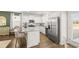 Modern kitchen with white cabinets, stainless steel appliances, granite countertops, and hardwood floors at 12086 Conrad Cir, Hampton, GA 30228