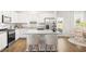 Modern white kitchen featuring granite counters, an island with seating, and stainless steel appliances at 12086 Conrad Cir, Hampton, GA 30228