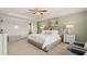 Spacious primary bedroom features a tray ceiling, carpeted floors, neutral walls, and plenty of natural light at 12086 Conrad Cir, Hampton, GA 30228