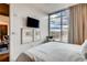 Bright bedroom featuring a large window, neutral decor, and wall-mounted TV at 1820 Peachtree Nw St # 811, Atlanta, GA 30309