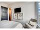 Cozy bedroom with neutral walls, tv, and a chair with a pillow next to the window at 1820 Peachtree Nw St # 811, Atlanta, GA 30309