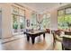 Bright game room features a pool table, tile floors, and multiple french doors opening to landscaped outdoor areas at 1820 Peachtree Nw St # 811, Atlanta, GA 30309