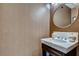 Modern powder room with marble countertop vanity, round mirror, and textured wallpaper, offering a sleek design at 1820 Peachtree Nw St # 811, Atlanta, GA 30309