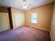 Bedroom with closet, window, and tan walls with purple carpet at 4050 Old Fairburn Rd, Atlanta, GA 30349