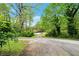 Driveway leading to a home surrounded by mature trees and greenery at 4050 Old Fairburn Rd, Atlanta, GA 30349