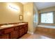 Main bathroom featuring dual sinks, a soaking tub, and a window at 4050 Old Fairburn Rd, Atlanta, GA 30349