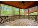 Screened porch with wood flooring and lattice design is perfect for enjoying nature and outdoor relaxation at 4050 Old Fairburn Rd, Atlanta, GA 30349