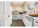 Galley kitchen with white appliances and cabinets offers a cozy space at 6433 Stone Terrace Ter, Morrow, GA 30260