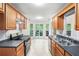 Bright kitchen featuring wood cabinets, black countertops, stainless steel appliances and a bay window offering natural light at 377 Tapley Rd, Villa Rica, GA 30180