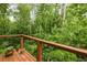 Wood balcony surrounded by lush greenery, offering a serene and private outdoor space at 385 Anders N, Chattahoochee Hills, GA 30268