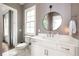 Bright bathroom featuring a toilet, vanity with white countertop, and round mirror at 385 Anders N, Chattahoochee Hills, GA 30268